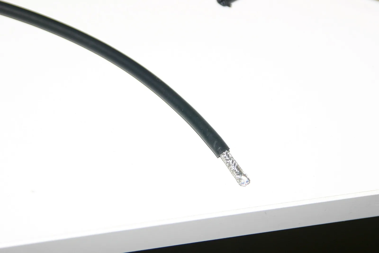 Photo of a balanced audio cable after the first strip cut, showing the outer jacket removed and the intact braided shield before de-braiding.