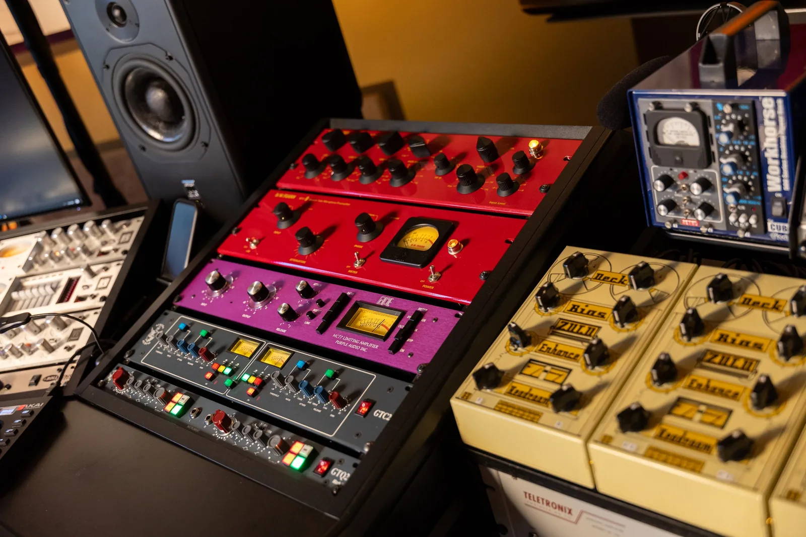 Photo of a rack of outboard hardware units including Handsome Audio Zulu saturators, a Purple Audio MC77 compressor, and D.W. Fearn tube preamp units mounted in a studio equipment rack.
