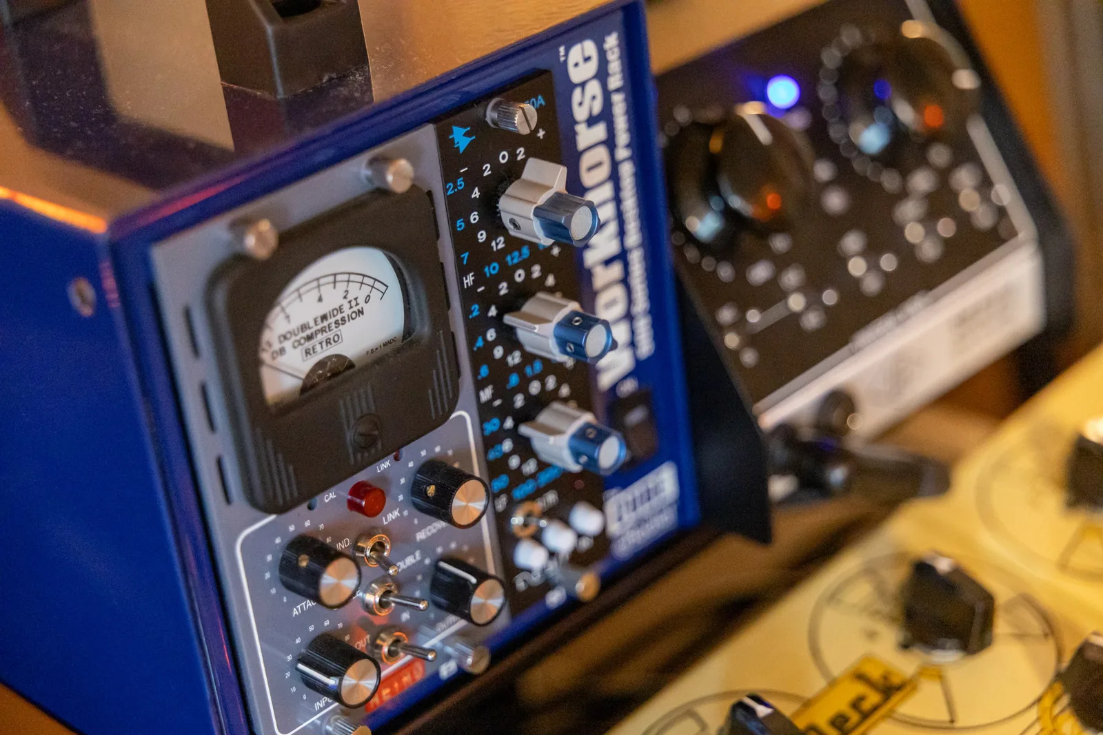 Photo of a Radial Workhorse 500-series powered rack chassis containing a Retro Doublewide II tube compressor and an API 550A equalizer module.
