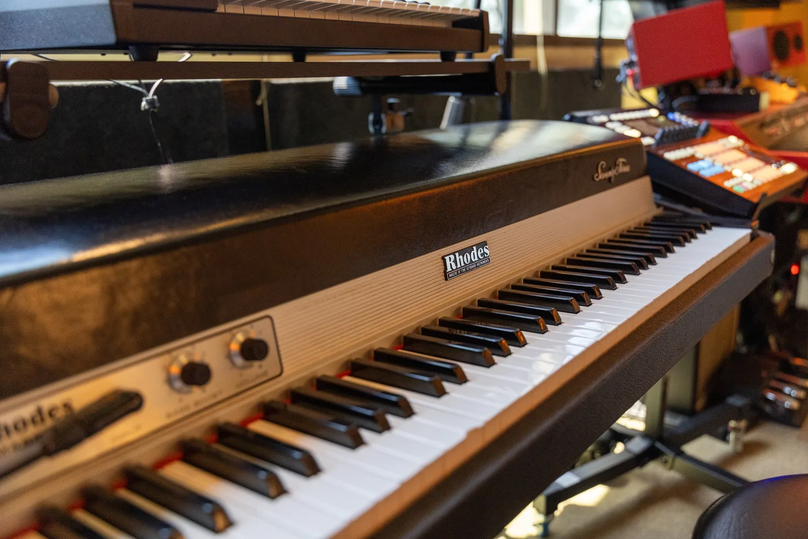 Photo of a Fender Rhodes Seventy Three electric piano, showing the keyboard, metal tine assembly, and electromagnetic pickup rail inside the open top.